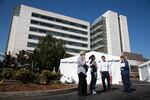 PeaceHealth Southwest staff talk in front of newly erected triage tents outside the emergency room in Vancouver, Wash. Hospitals are taking steps to prepare for a surge in patients from the novel coronavirus.