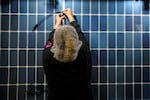An employee works on a solar panel inside the Hanwha Qcells Solar plant, Monday, Oct. 16, 2023, in Dalton, Ga. The Korean company is opening what it says is the first solar panel factory to begin production in the U.S. since the passage of President Joe Biden’s signature climate legislation. (AP Photo/Mike Stewart)