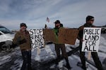 Environmentalists hold signs supporting federal land management at the Malheur National Wildlife Refuge.