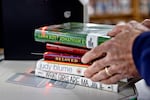 Parents Against Bad Books co-founder Tom Harrison grabs a stack of what group members call age-inappropriate books that they checked out from the Idaho Falls Public Library on Oct. 4.