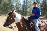 Avan Garcia rides Blackhat at a wild horse round up on the Warm Springs Reservation on June 22, 2019.