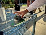 A student unlocks their Yondr pouch outside Grant High School on Wednesday, Aug. 28, 2024. The new pouches are supposed to keep phones, earbuds and smartwatches away from students for the full school day, including lunch and passing periods.