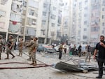 People and members of the military inspect the site of an Israeli strike in the southern suburbs of Beirut, Lebanon, on Friday.