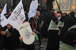 Pilgrims carry religious flags and banners during the Arbaeen pilgrimage near the Imam Hussein Shrine in Karbala, as millions of worshippers from Iraq and abroad continue to gather for the annual religious commemoration.
