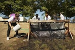 Woodburn High School students filter buckets of dirt with a hose and screens. They're looking for tiny bones from ancient frogs, muskrats and beavers.