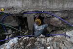 A member of a water cartel in the slum community of Kibera, hammer in hand, cuts into a municipal water pipe to siphon off water illicitly. That water is then sold to residents who aren't able to get government-supplied water.