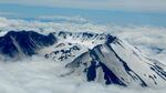 The plane got a good view of Mount St. Helens peeking through the clouds with Mount Hood in the background.
