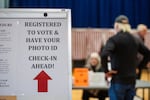 A sign informs registered voters to have their photo IDs ready to check in at a polling place in Lancaster, N.H., in 2024.