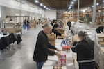 Employees with the Oregon Office of Resilience and Emergency Management pack food boxes at a warehouse in Salem as part of a training to see how they can respond to future food emergencies.