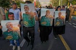 Demonstrators carry posters of top Iranian commanders killed in Friday's Israeli strikes on Tehran, during the Muslim Shiite holiday of Eid al-Ghadir, which commemorates the Prophet Muhammad naming Ali, revered as the first Shiite imam, as his successor, in Tehran, Iran, Saturday, June 14, 2025. 