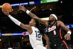 Memphis Grizzlies guard Ja Morant (12) blows by Portland Trail Blazers forward Jerami Grant (9) in the first half of an NBA basketball game Monday, Nov. 25, 2024, in Memphis, Tenn. The Grizzlies won 123-98.