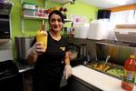 An employee at Frutas Locas makes one of their signature mango smoothies. The popular Fourth Plain business specializes in Mexican-style fruit cups and drinks.
