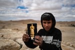 PALMYRA, Syria, 02/21/25 A young boy selling souvenirs above the ruins of Palmyra. The ancient site is largely deserted now, but locals are hoping for a return of tourists now that the country has reopened to international visitors after the fall of the regime of Bashar al-Assad to rebel fighters last December. Ayman Oghanna for NPR