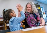 Kindergarten student Abigail Lemus Guerrero, left, gets a high-five from teacher Liz Knapp, during class at Newby Elementary School in McMinnville, Dec. 12, 2023. 