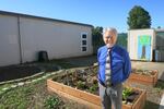 Alder Elementary School principal Rob Stewart stands in a community garden, outside the Montessori preschool room.