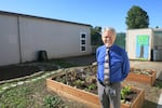 Alder Elementary School principal Rob Stewart stands in a community garden, outside the Montessori preschool room.