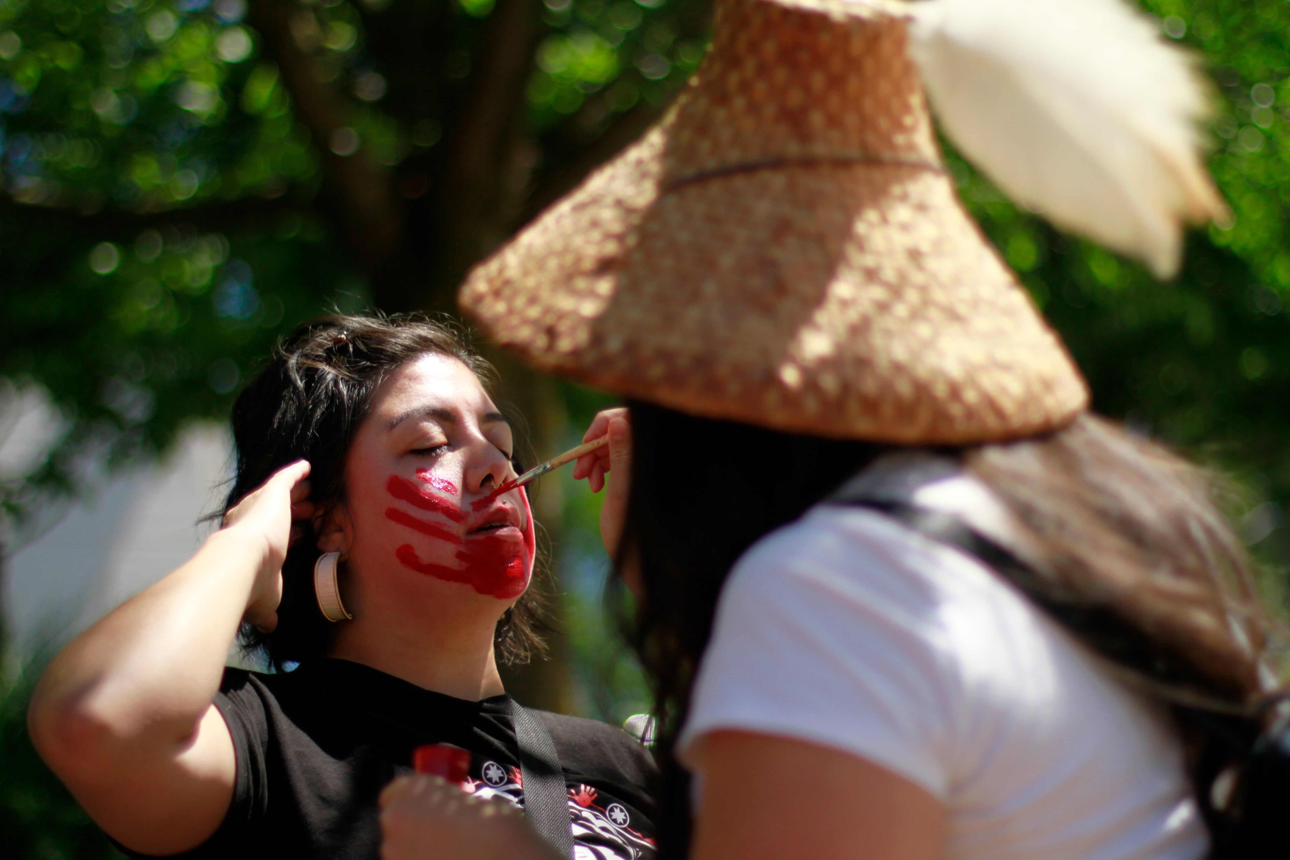 Ashleigh Coon, Diné, Early Childhood Program Co-Director for Future Generations Collaborative, waits patiently while another attendee paints a red handprint over her mouth, which visually symbolizes the silencing of missing and murdered women, as well as the lack of law enforcement and media attention to the epidemic.