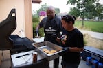 (from left) The Fathers Group co-founders Kelly Musgrove and Natashia James make cheeseburgers at The Fathers Group barbeque in Redmond, Ore., on Sep. 5, 2024.