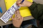 An 8th-grader works on a class project at Paw Paw Middle School on Dec. 2, 2021, in Paw Paw, Michigan. The students were asked to write a word that was important to them and their work in the classroom. They then added the words to a poster to serve as a class "contract." The district has upped its social-emotional curriculum during the pandemic, as more students struggle. That is common nationwide. An  AP-NORC/MTV poll found that nearly half of U.S. teens said the pandemic has made it harder to be happy and maintain their mental health.