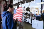 Morgan Minick paints a sign thanking former President Jimmy Carter in his hometown after he died Sunday in Plains, Ga. President Carter lived to be 100 years old, making him the longest living U.S. president in history.