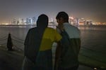 Raneem Hijazi walks a few steps with help from her husband, Asaad Sakallah, to see the skyline of Doha from the port. They take some photos in the city and later get ice cream, building new memories together in this new life.