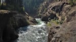 white water river rapids running through rocky canyon.