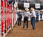 People gather in the arena near the chutes that holds livestock before competitions.