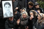 People mourn at the grave of flight attendant Hokume Aliyeva during a funeral of the crew members of the Azerbaijan Airlines Embraer 190 killed in a deadly plane crash in Kazakhstan this week, at the II Alley of Honor in Baku, Azerbaijan, Sunday, Dec. 29, 2024.