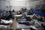 Young children lie inside a pod at the Donna Department of Homeland Security holding facility, the main detention center for unaccompanied children in the Rio Grande Valley run by U.S. Customs and Border Protection, in Donna, Texas, Tuesday, March 30, 2021. The children are housed by the hundreds in eight pods that are about 3,200 square feet in size. Many of the pods had more than 500 children in them. The Biden administration on Tuesday for the first time allowed journalists inside its main detention facility at the border for migrant children, revealing a severely overcrowded tent structure where more than 4,000 kids and families were crammed into pods and the youngest kept in a large play pen with mats on the floor for sleeping.