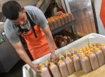 Jonathan Hernandez loads plastic jugs of freshly pressed, preservative-free apple juice, also offered on tap, carbonated or plain, at the farm.