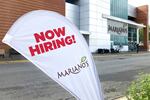 A "now hiring" sign in the parking lot of Mariano's grocery store.