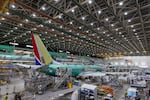 FILE - Boeing employees work on the 737 MAX on the final assembly line at Boeing's Renton plant, June 15, 2022, in Renton, Wash. 