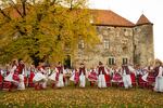 The Transcarpathian Folk Choir performs a song and dance for a music video that they are working on to share their music. Ukraine's St. Miklos Castle, which is now an arts exhibit space, a meeting place and museum for local history, provides the backdrop.