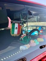 A Mexican flag and rag doll sit amongst other decorations in Aimee Sarai Velazquez’s car.