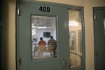 In this 2017 file photo, two ICE detainees sit on top of a metal table watching television at NORCOR.