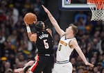 Portland Trail Blazers guard Dalano Banton, left, goes up for a basket as Denver Nuggets guard Christian Braun defends in the first half of an NBA basketball game, Monday, Feb. 10, 2025, in Denver.