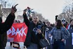 People protest as law enforcement officers attend to the scene of the shooting involving federal law enforcement agents, Wednesday, Jan. 7, 2026, in Minneapolis.