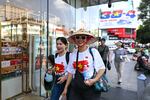 Women wearing Vietnamese national flag T-shirts walk past the Saigon Centre shopping complex in Ho Chi Minh City on April 29, 2025, ahead of celebrations to mark the 50th anniversary of the end of the Vietnam War.