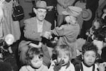 FILE - Oregon farmer Harry Holt, left, checks the identification of one of the Korean orphans he brought from South Korea as they arrive in San Francisco, Dec. 17, 1956.