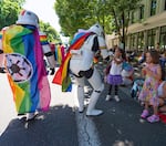 Jaine Williams, center left, and Cam Camacho, right, receive high fives from two Portland Pride parade attendees dressed as Star Wars Stormtroopers.