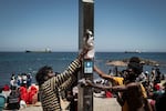 Migrants fill bottles with water on the beach next to the CETI (Centros de Estancia Temporal de Inmigrantes) on August 2, 2026 in Ceuta, Spain.