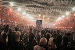 A mourner holds a portrait depicting Iran's Supreme Leader Ayatollah Mojtaba Khamenei, top, and his late father, Ayatollah Ali Khamenei, as mourners wait for the funeral procession for the elder Khamenei outside the Imam Hussein Shrine in Karbala, Iraq, Wednesday, July 8, 2026.