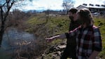 Two people look at a beaver dam and pond in downtown Phoenix