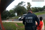 In this image taken from Sept. 19, 2019, Orlando Police Department body camera video footage, Orlando Police Officer Dennis Turner leads 6-year-old Kaia Rolle away after her arrest for kicking and punching staff members at the Lucious & Emma Nixon Academy Charter School in Orlando, Fla.