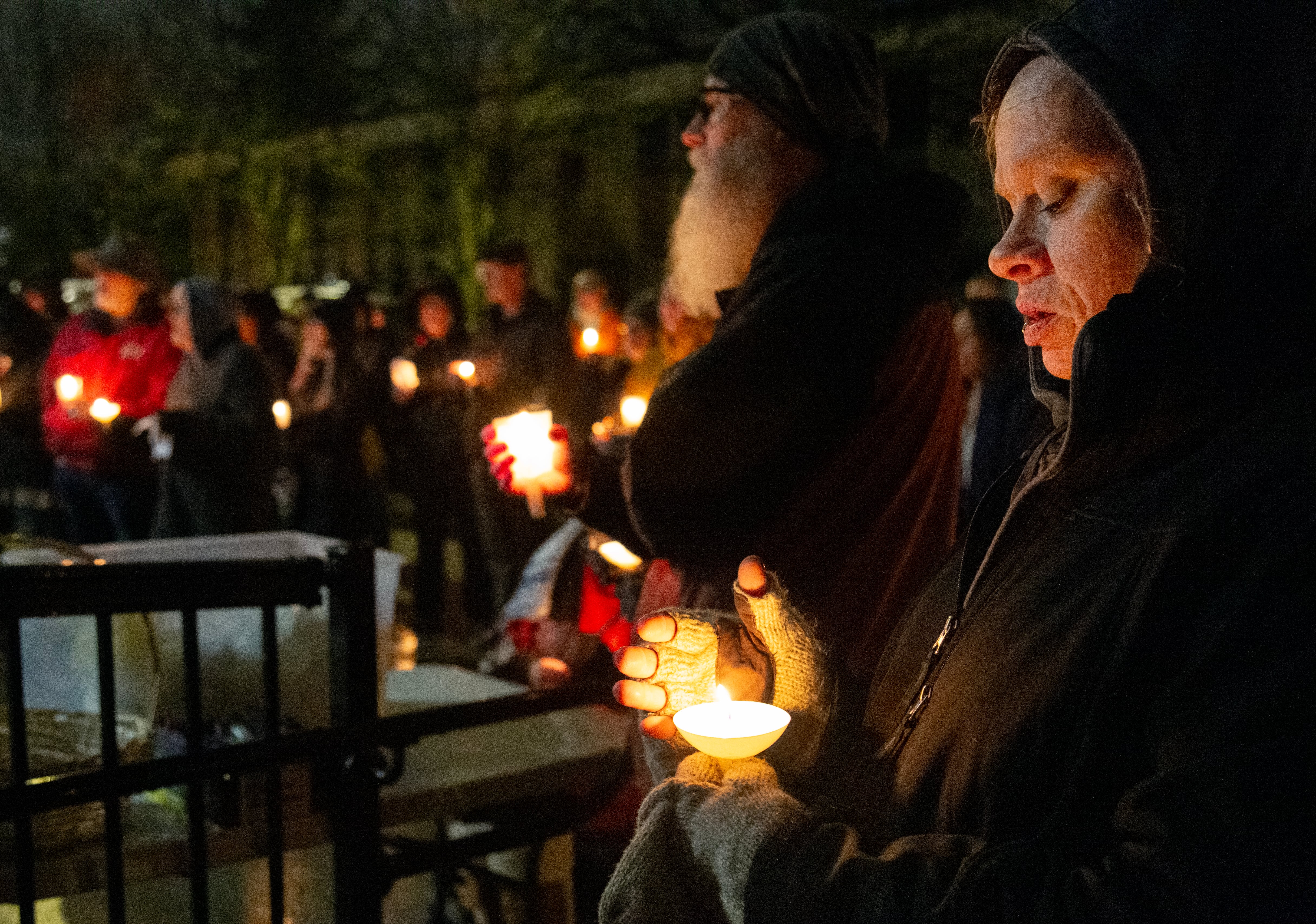 A woman holds a candle during the Vancouver homeless persons memorial at St. Paul Lutheran Church on Dec. 21, 2025.