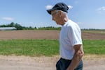 Mike Bondi walks through Oregon State University’s 160-acre North Willamette Research and Extension Center in Aurora, Ore., on July 1, 2022. Bondi, the former director at the center, says the soil in the Willamette Valley is what allows such a variety of crops to be grown.