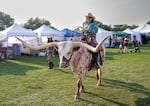 Frank Rendon rides a longhorn steer through the Crook County Fair in Prineville. Rendon says he expected the smoke wouldn't keep everyone away. "I think the diehards will be out here today."