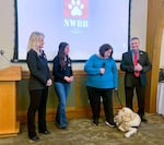 Northwest Battle Buddies leaders Shannon Walker, left, and Ovie Muntean, right, stand with a trainer and recipient at the veterans and service dog graduation ceremony at the Royal Oaks Country Club in Vancouver, Washington, on Feb. 16, 2024. Northwest Battle Buddies is a nonprofit based in Southwest Washington that trains service dogs for military veterans from across the country.