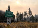 A roadside sign welcomes people to Blue River, Oregon, as smoke fills the skies from the 2020 Holiday Farm fire.