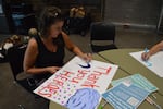 Sisters resident Katie Roberts makes a sign thanking firefighters and first responders working the Akawa Butte Fire during a public meeting at Sisters High School, July 23, 2026.